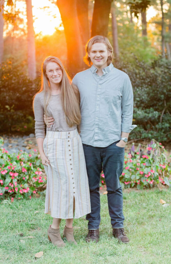 Seth Fulmer and his wife together standing in their yard with trees behind them